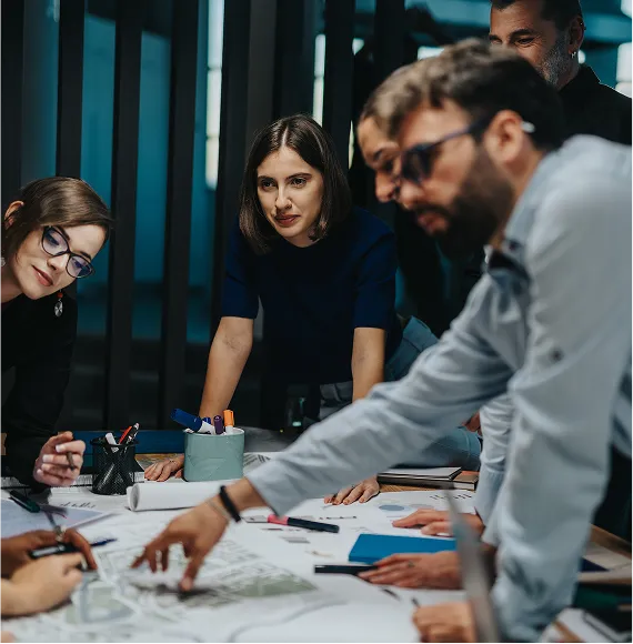 Team in einem modernen Büro bei der konzentrierten Zusammenarbeit an einem Projektplan, mit Fokus auf Strategie, Innovation und effiziente Teamarbeit.